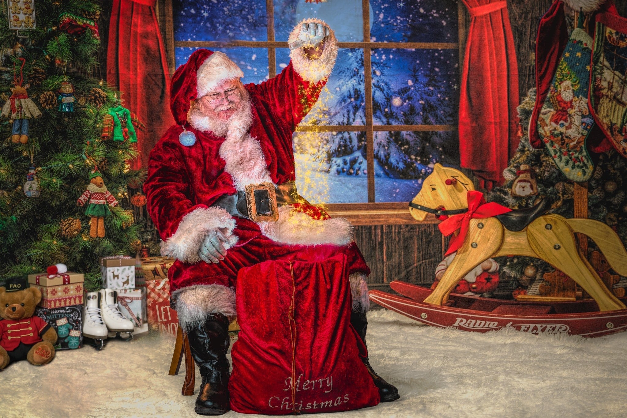Santa Claus performing magic in front of Christmas backdrop
