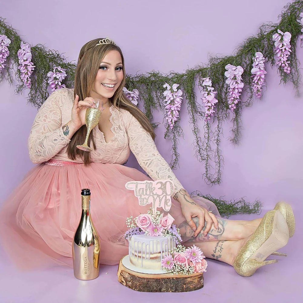 Girl drinking in front of purple backdrop