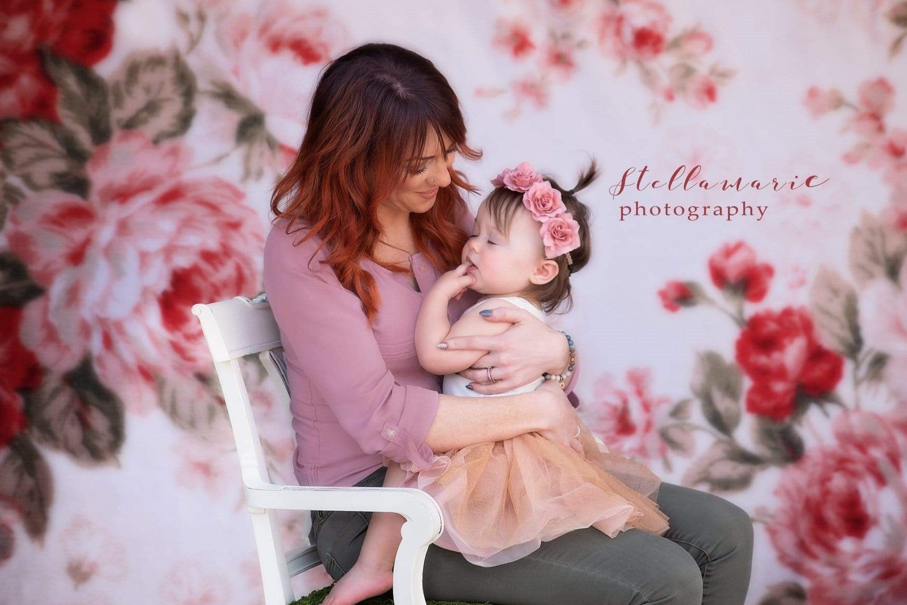 My mother held me in her arms and sat in front of a floral backdrop