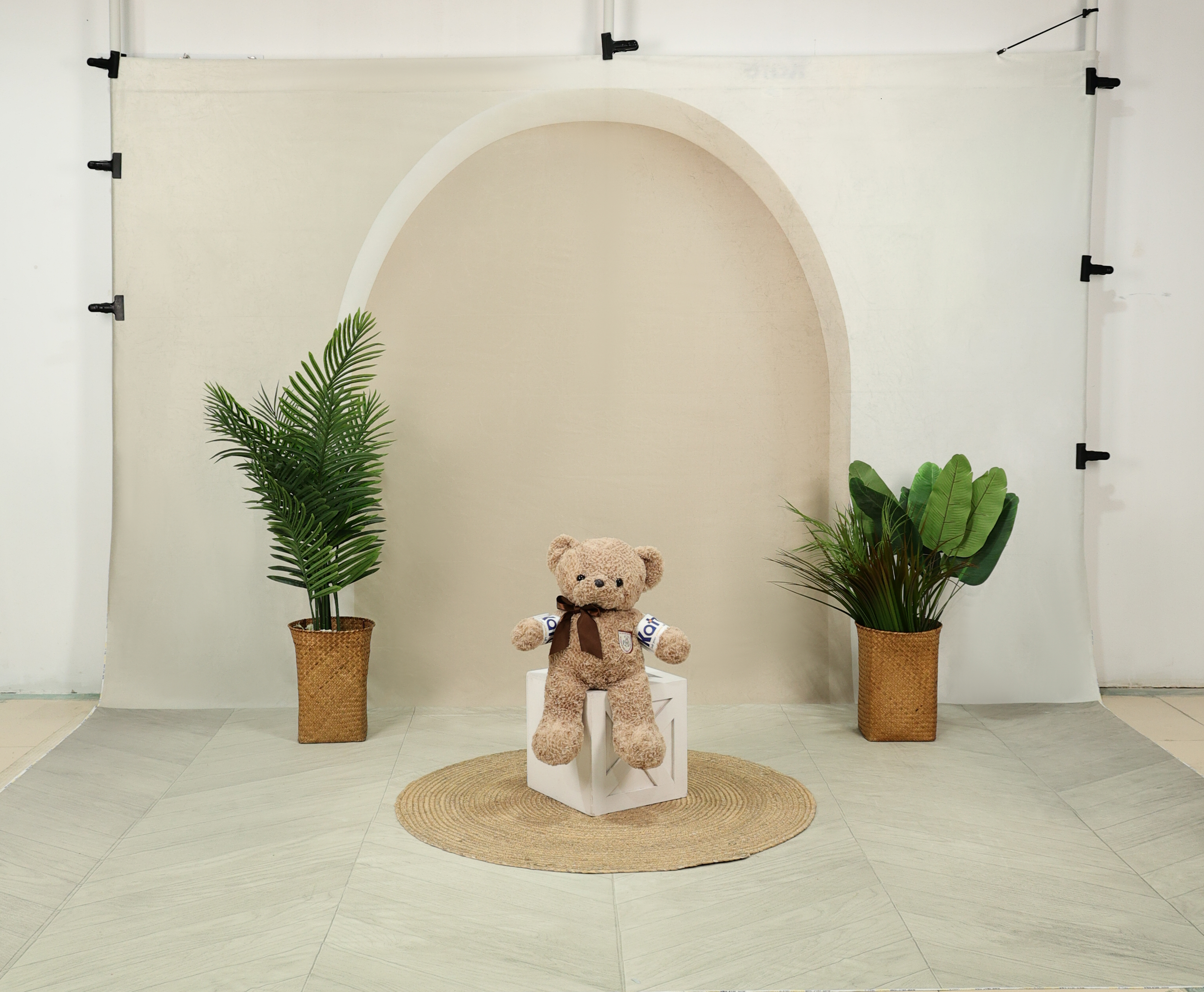 Teddy bear sitting in front of boho backdrop