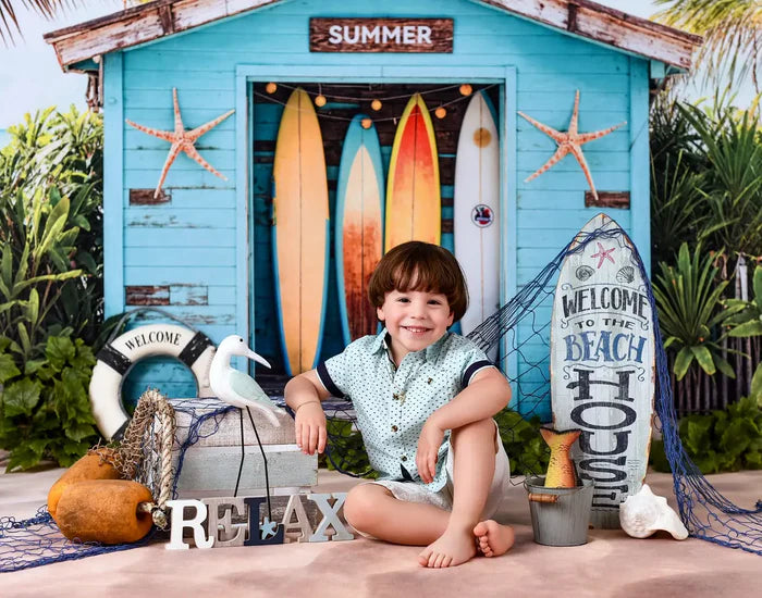 Boy sitting in front of summer fruit stand backdrop