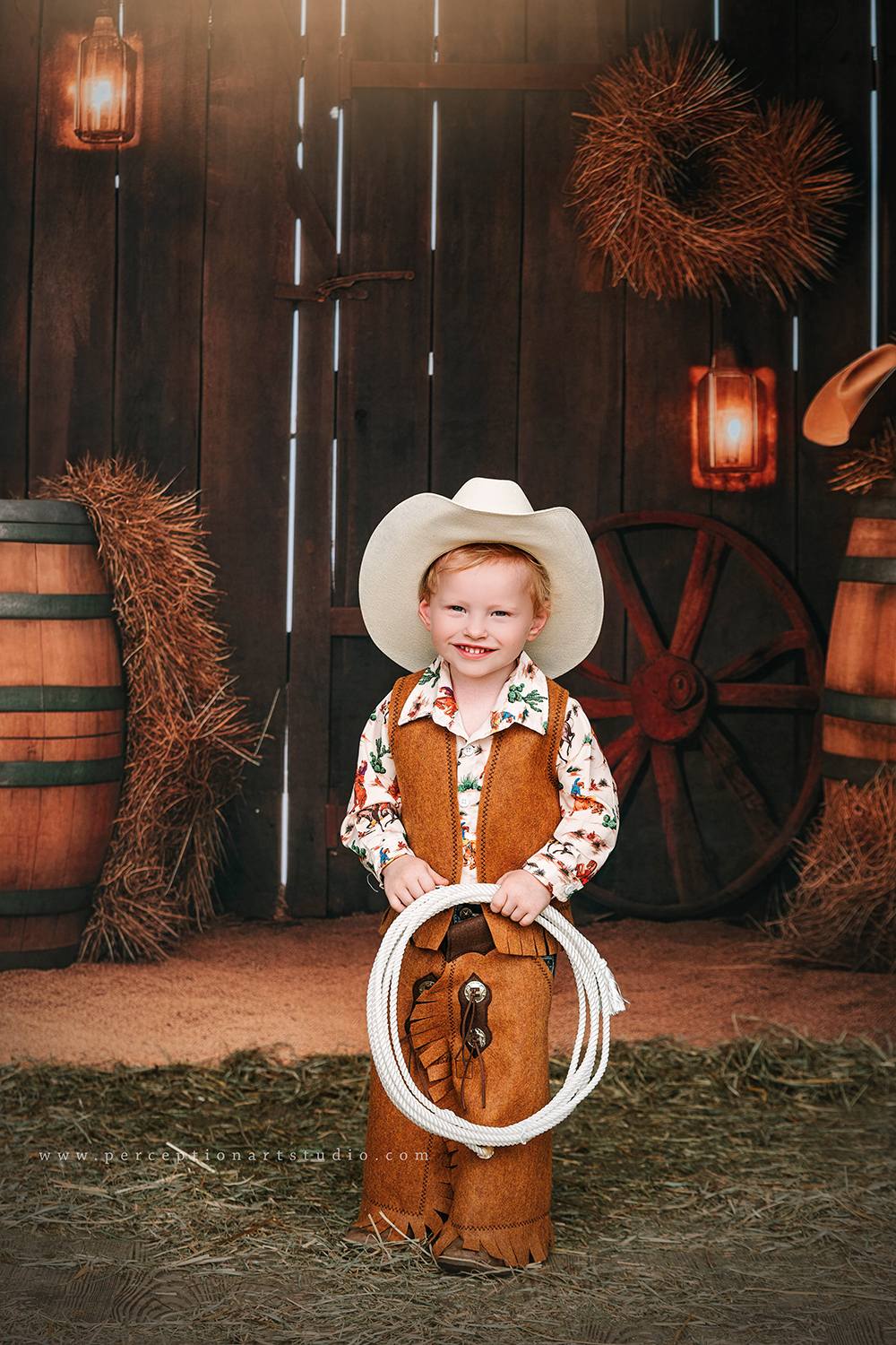 Little boy standing in front of autumn barn door backdrop