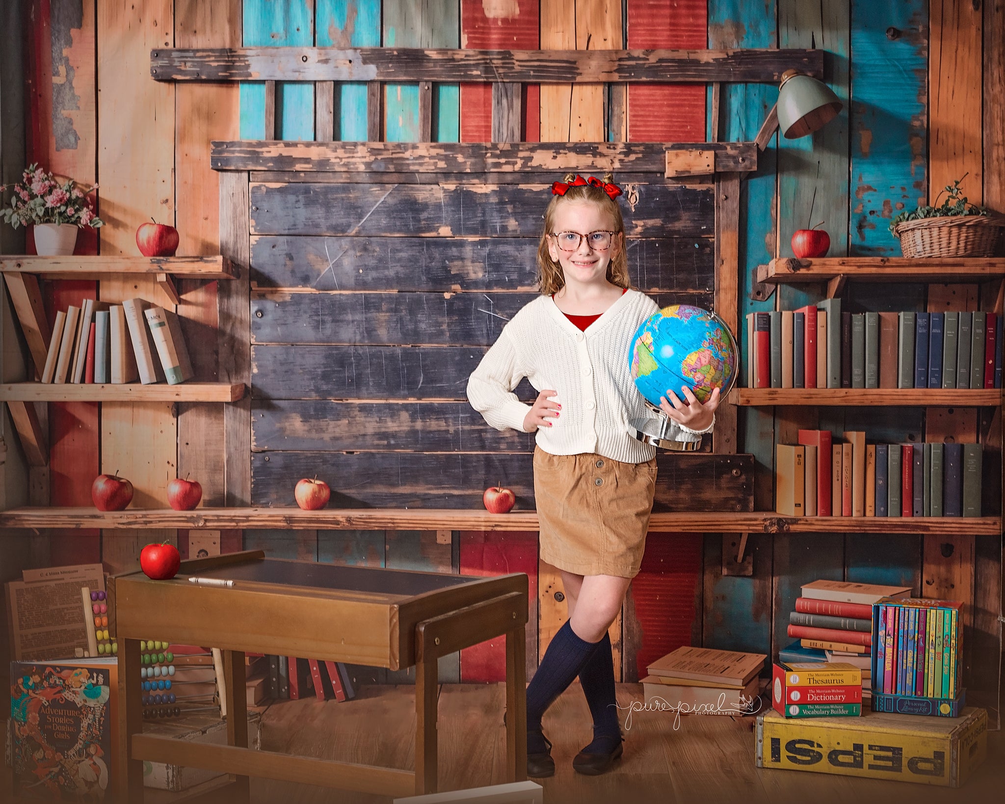 Girl holding a globe standing in front of back to school backdrop