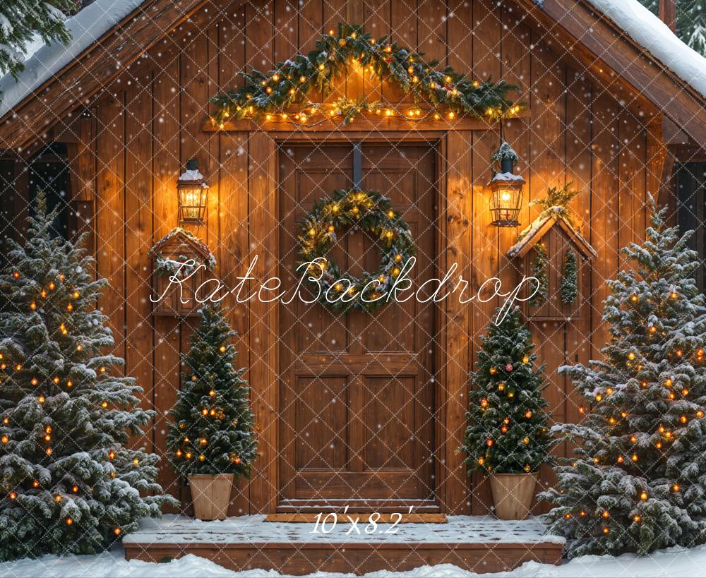 Decorative backdrop of a wooden cabin with Christmas trees and lights, featuring the brand 'KateBackdrop'.