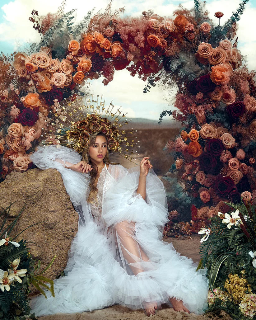 Girl leaning on a stone in front of an artistic floral backdrop