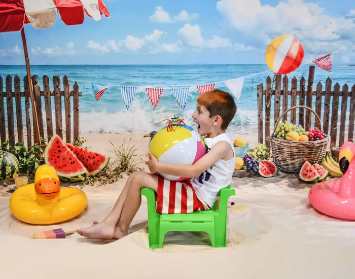 Boy holding a ball sitting in front of the sea beach backdrop