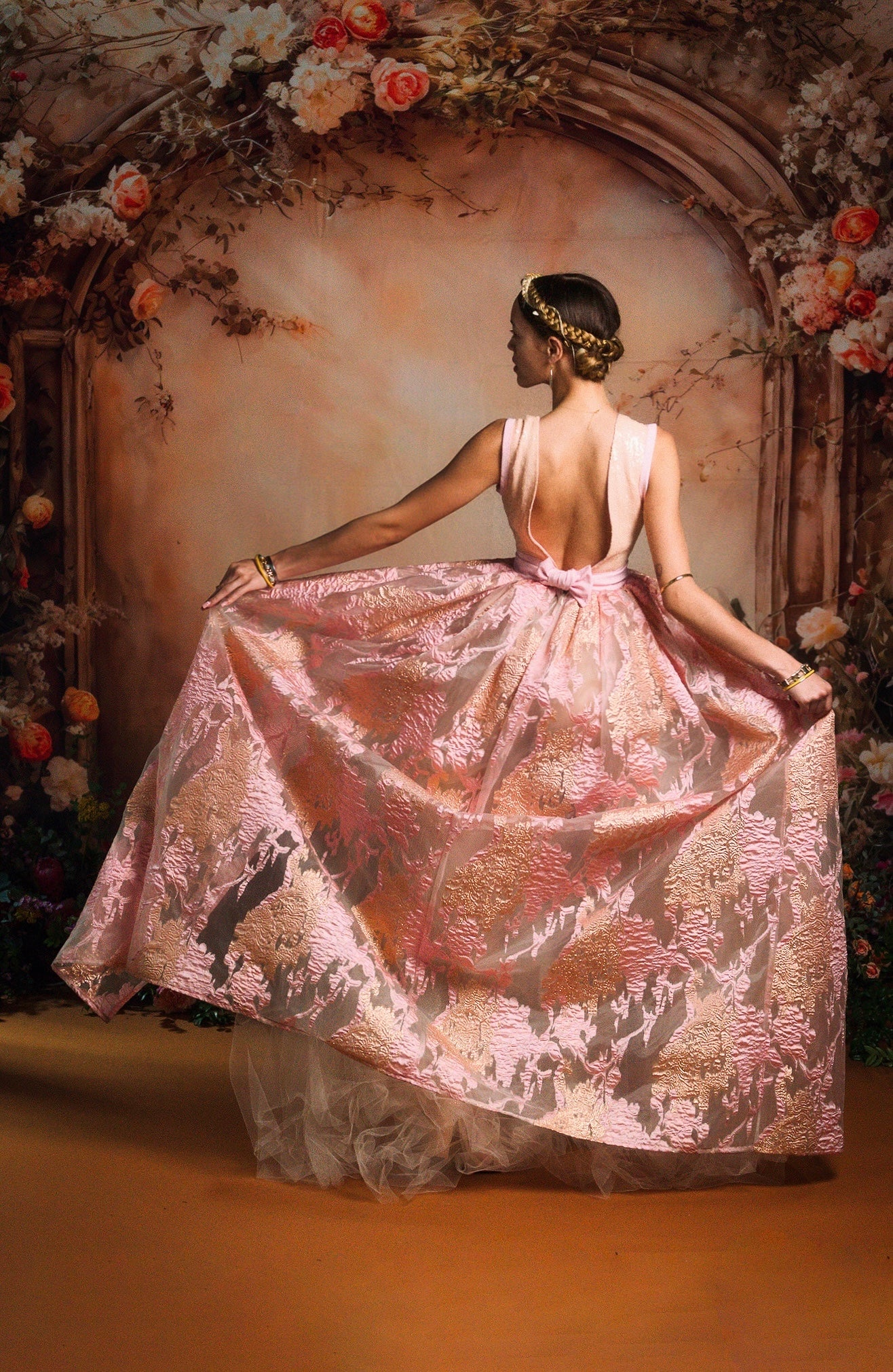 A girl holding her skirt stands in front of the Beige Flower Wall Spring Fleece Backdrop