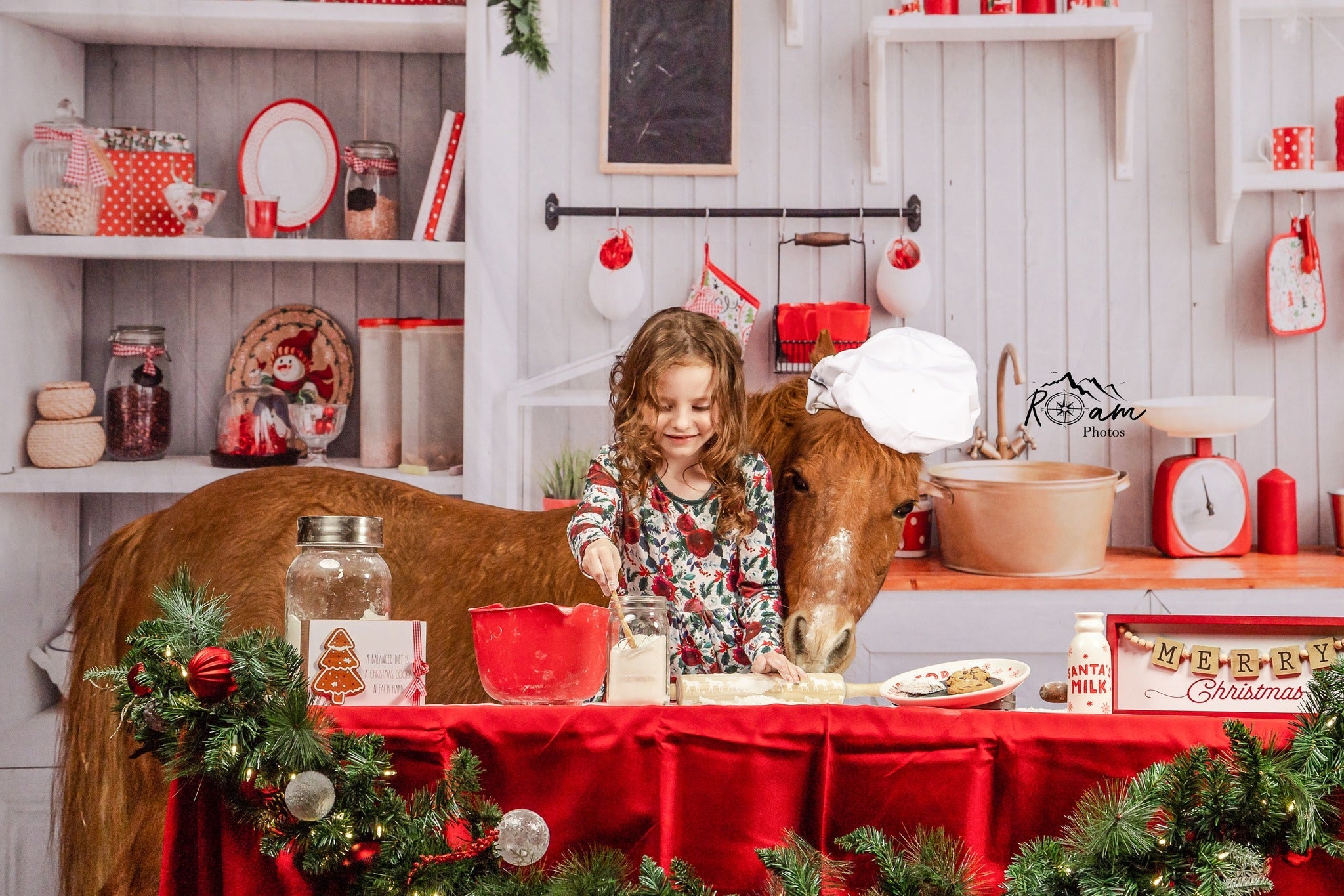 Little girl and cow in front of Christmas kitchen backdrop