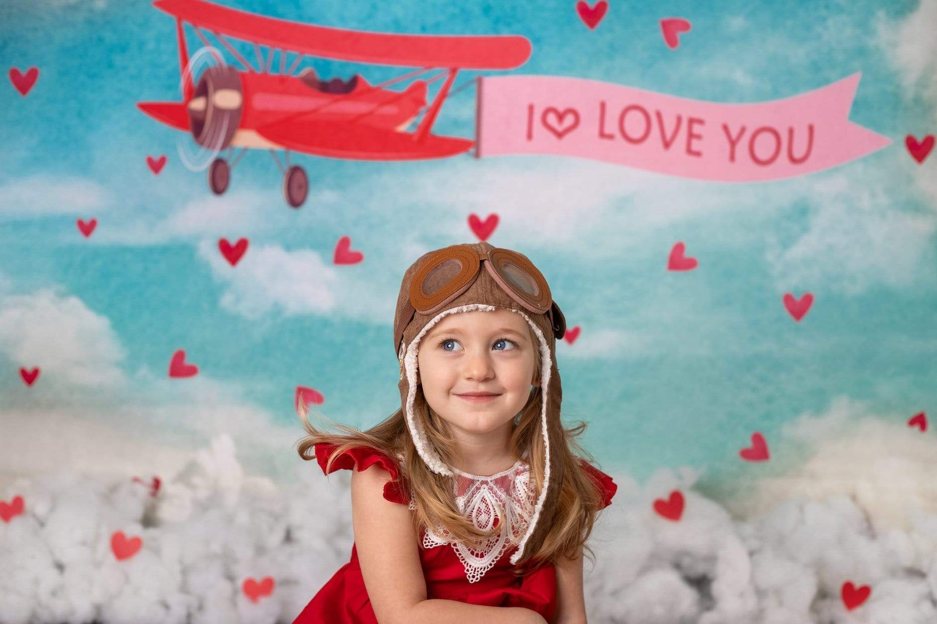 Girl in front of Valentine's Day airplane backdrop