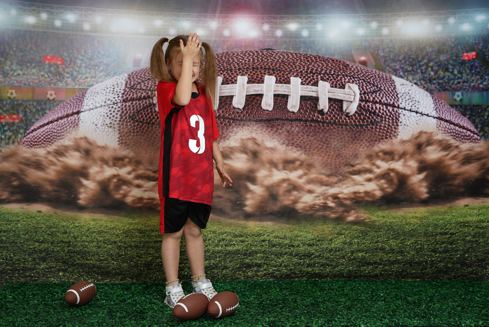 Girl covering her head standing in front of rugby backdrop