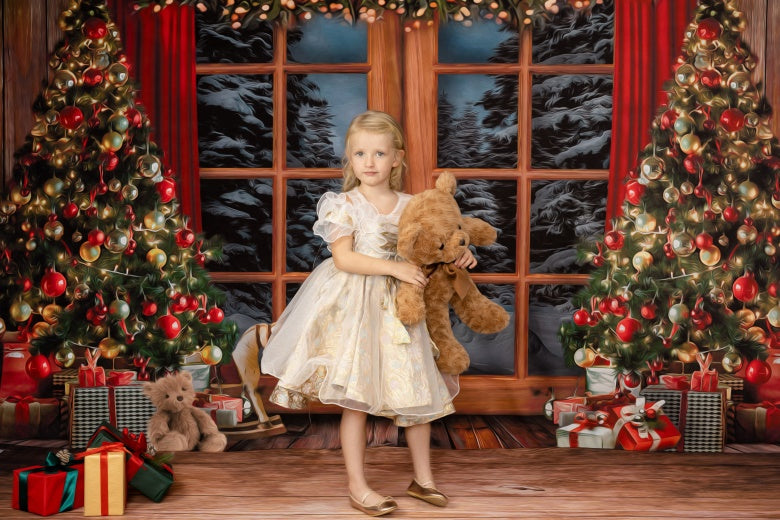 Girl holding teddy bear standing in front of Christmas window backdrop