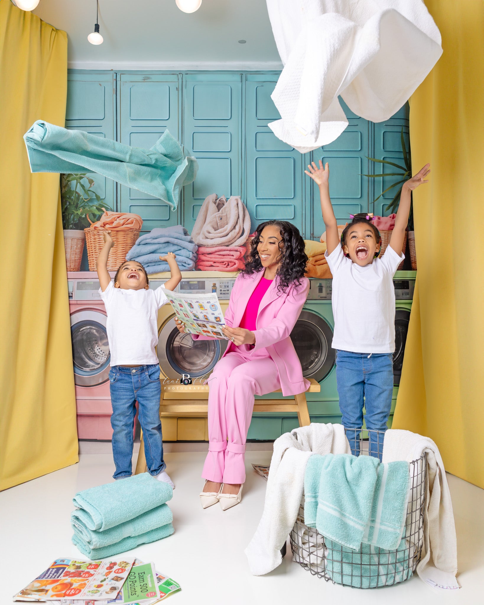 Cheering mother and kids in front of washing machine backdrop