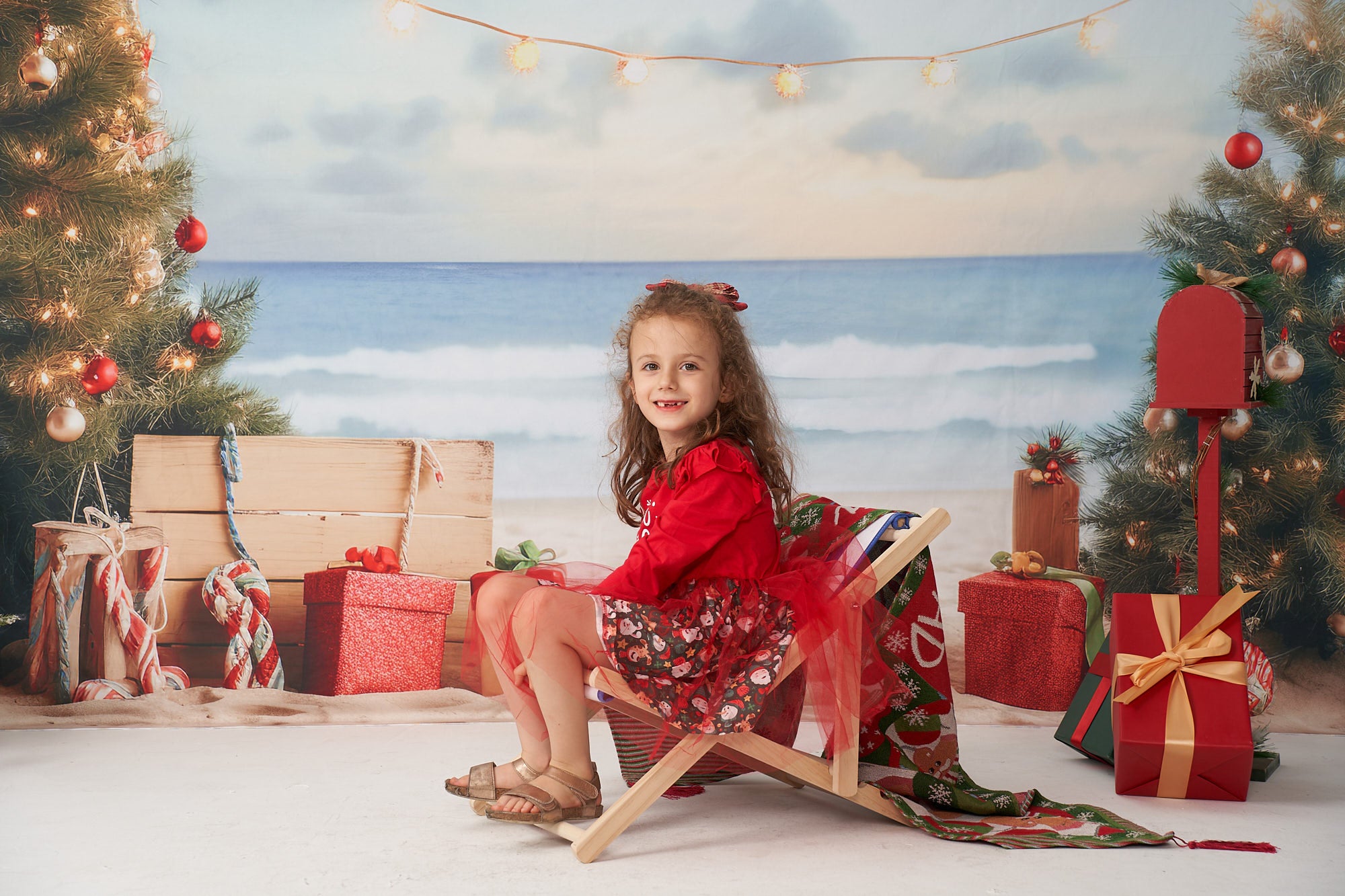 Resting girl sitting on a deck chair in front of Beach Christmas Backdrop