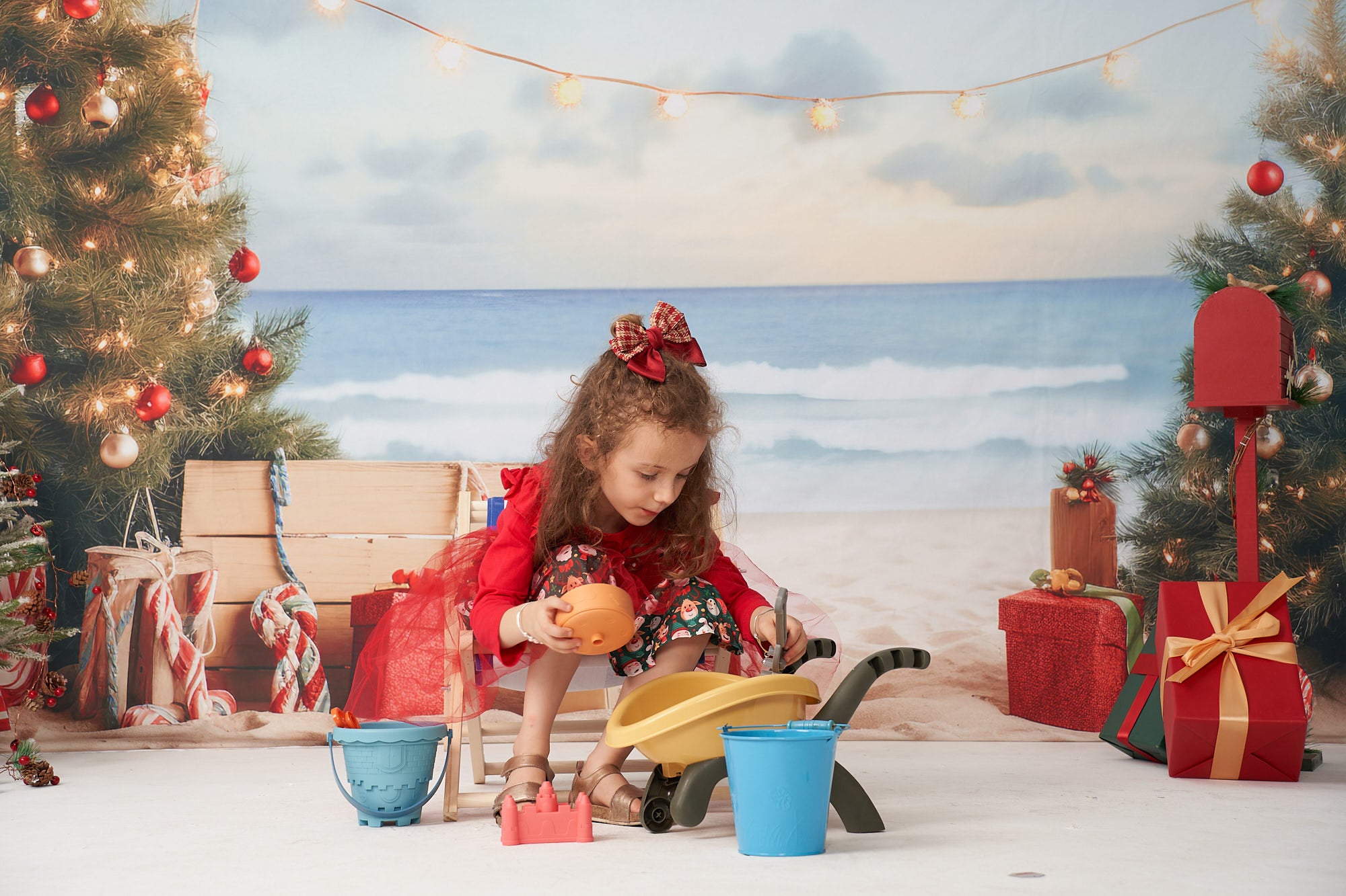 Playful girl squatting in front of Beach Christmas Backdrop