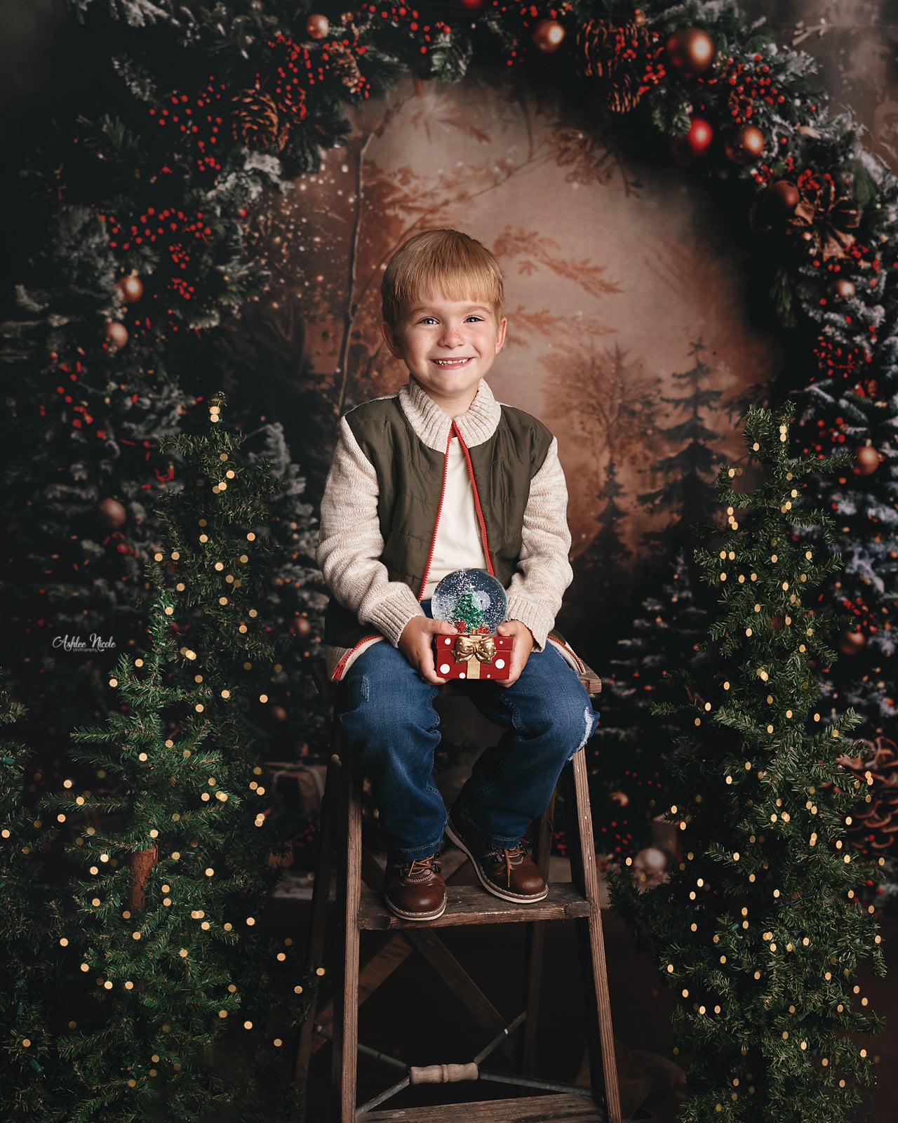 Boy holding crystal ball sitting in front of Christmas Green Plan Backdrop