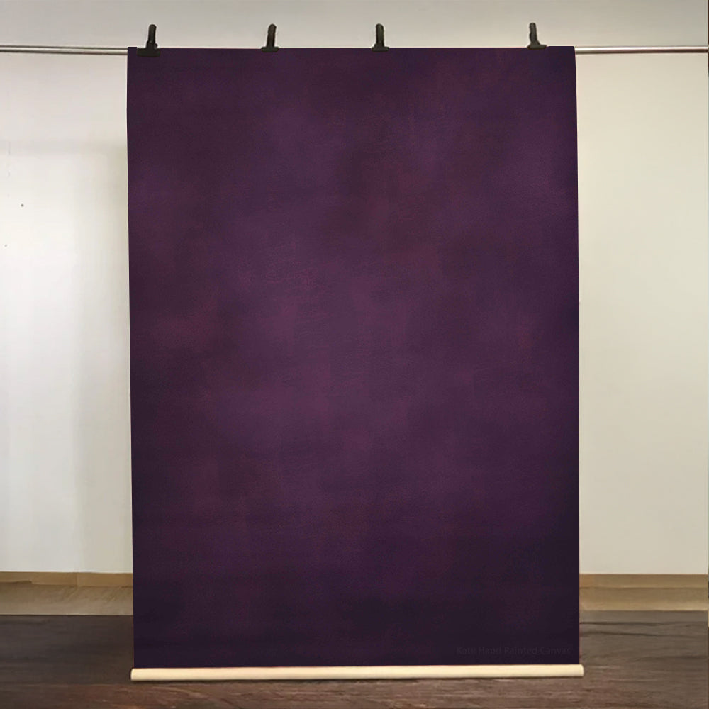 Purple backdrop paper on a stand against a white wall.